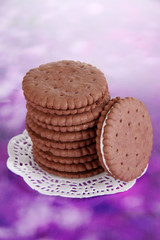 Chocolate cookies with creamy layer on purple background
