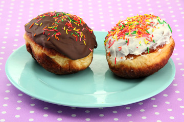 Tasty donuts on color plate on color background