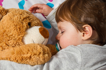 Sweet child sleeping with teddy bear