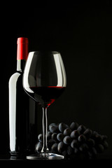 bottle with red wine and glass and grapes