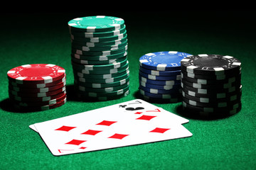 Cards and chips for poker on green table