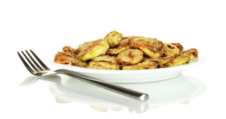 Fried zucchini in a white plate with fork isolated