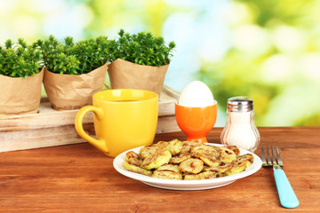 Fried zucchini with eggs and coffee for breakfast