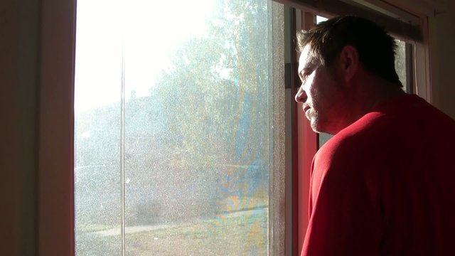 Man Looking Out Window
