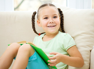 Little girl reads a book