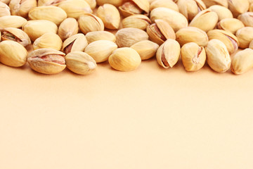 tasty pistachio nuts, on beige background