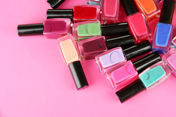 Group of bright nail polishes, on pink background