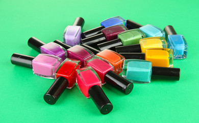 Group of bright nail polishes, on green background