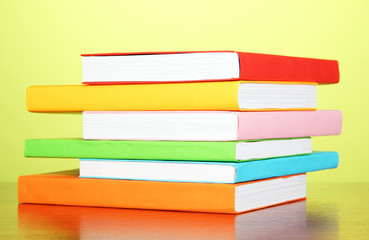 Stack of multicolor books   on green background