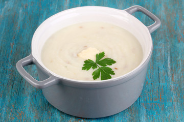 Mashed potatoes in saucepan on blue wooden table
