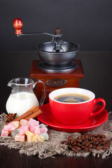 Red cup of coffee with rahat delight, milk and coffee mill