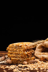 assortment of baked bread on wooden table and black background
