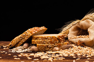 assortment of baked bread on wooden table and black background