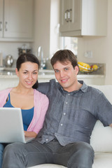 Young couple relaxing while using the laptop