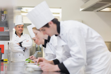 Chef supervising others making salads