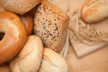 Bread in the basket with a roll on a wooden board