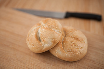 Buns and a knife lying on the background