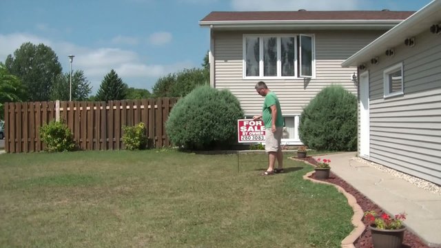 Placing For Sale Sign in Yard - Selling House