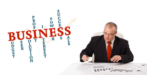 businessman sitting at desk with word cloud