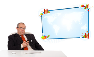 Businessman sitting at desk and holding a mobilephone with copy