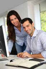 Young office workers in front of desktop computer