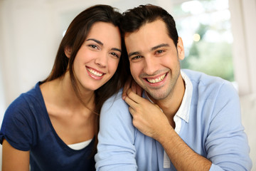 Portrait of cute young couple sitting in sofa