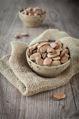 Bunch of broad beans in a bowl on  awooden background