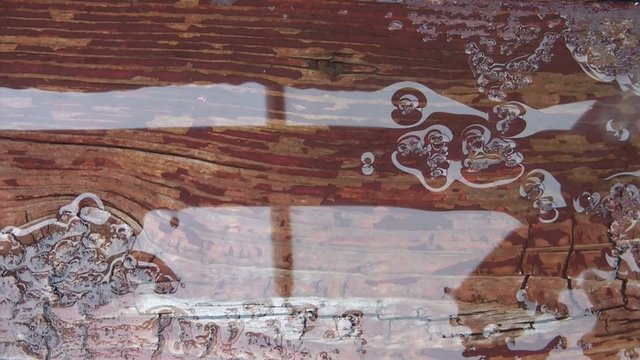 Water Dripping in Puddle on Rustic Deck