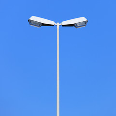 Double street lamp post on blue sky background