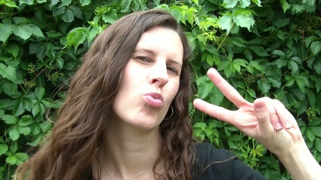 Woman Kissing, Giving Peace Sign