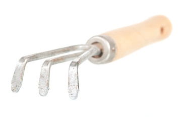 Rusty garden rake with a wooden handle over a white background