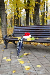 Santa's cap and an umbrella on a bench.