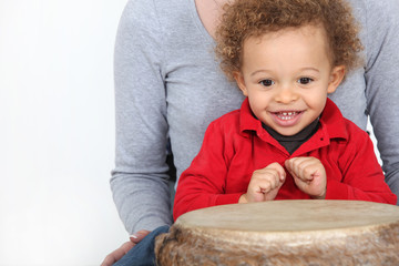 Little boy sat by bongo drum