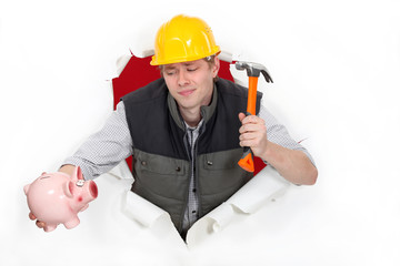 Construction worker with a hammer and piggy bank