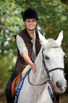 young horsewoman with white horse
