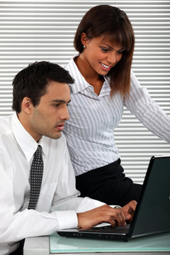 Man and woman sitting with computer