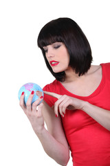 Brunette holding miniature globe