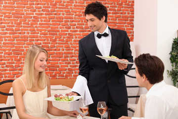 Waiter serving plate of food