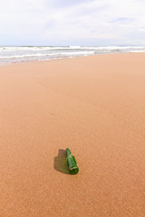 Fototapeta na wymiar plaża z pustej butelki na pierwszym planie