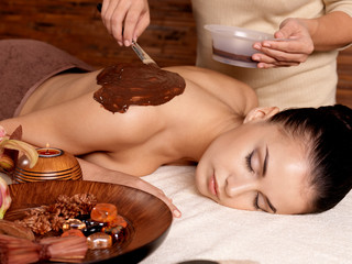 Spa therapy for young woman receiving cosmetic mask