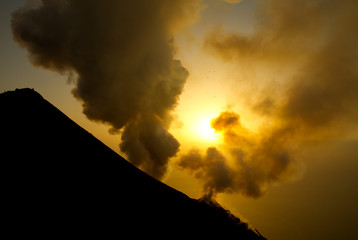 volcan fumant au coucher du soleil