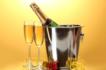 Champagne bottle in bucket with ice and glasses of champagne,