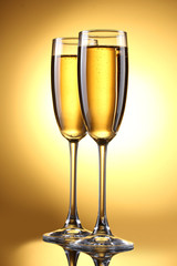 glasses of champagne on yellow background