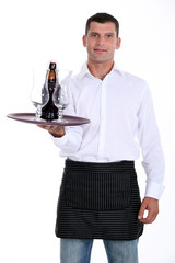 waiter holding tray with glasses and bottle