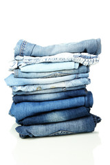 Lot of different blue jeans isolated on white