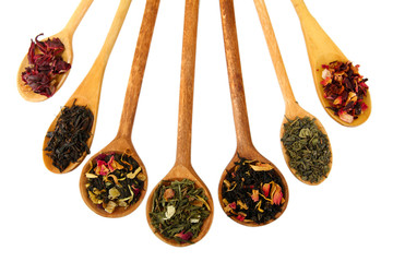 assortment of dry tea in spoons, isolated on white