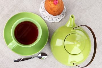 Obraz na płótnie Canvas Widok z góry na filiżankę herbaty i czajniczek na obrusy