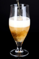 Beer pouring into glass isolated on black