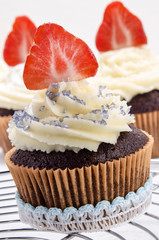 Cupcake mit Erdbeere und blauen Zuckerstreuseln