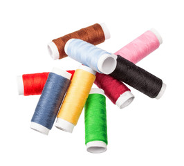 Many-coloured bobbins of thread isolated on white